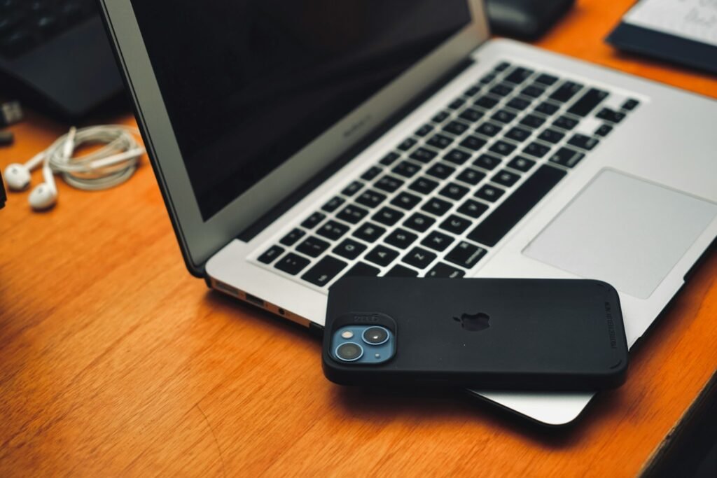 Photo by Daniel Octavian a laptop computer sitting on top of a wooden desk